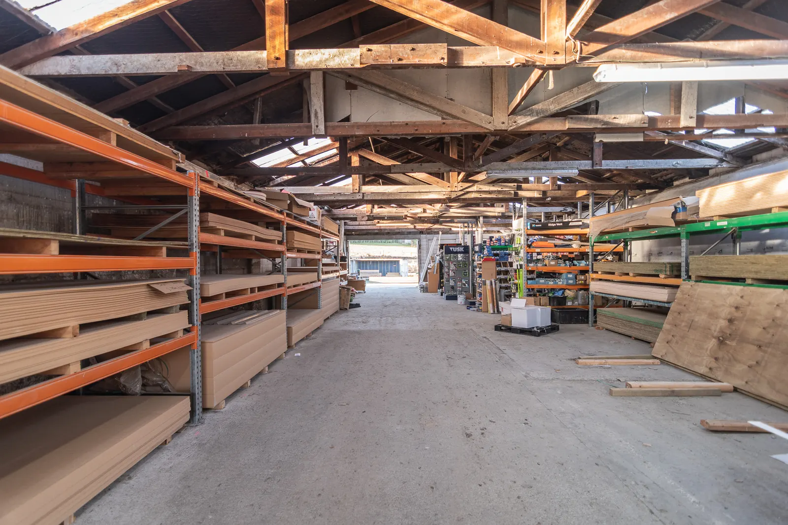 The main aisle inside the BuildLink Timaru store, racked both sides with timber and board