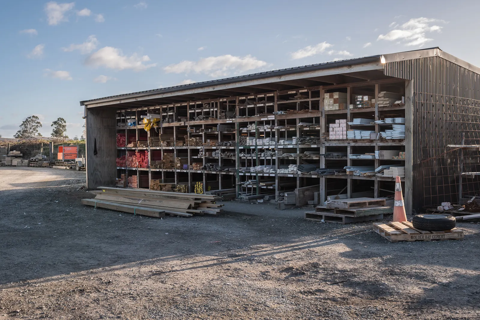 A long open-bay pole shed at the BuildLink Timaru yard, racked out with timber