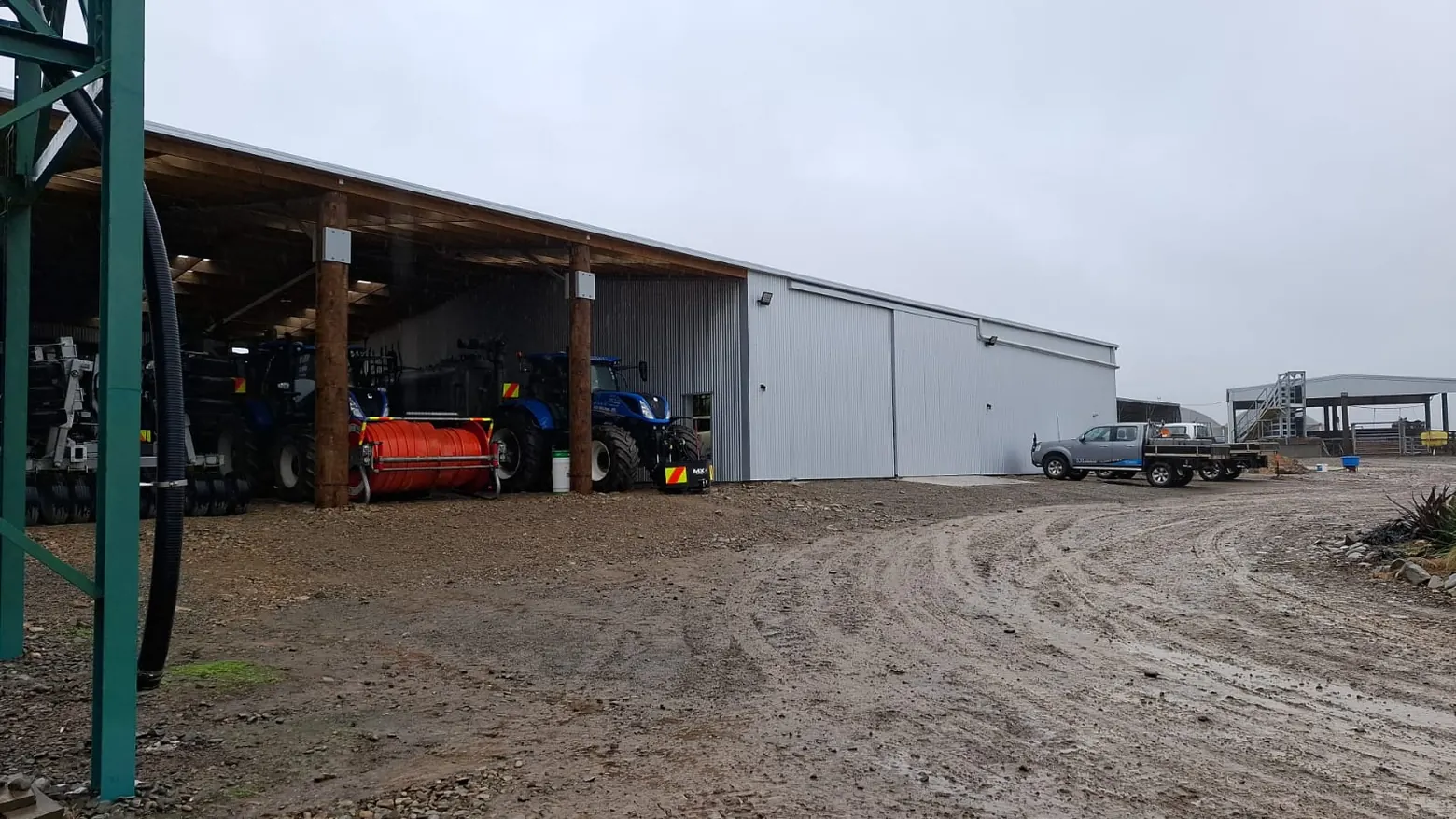 A finished farm shed from BuildLink Timaru, with tractors and machinery parked under the open bays